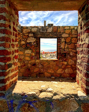 Una casa en obra negra, reflejando el lujo detrás en la pared párese un cuadro colgado en la pared.