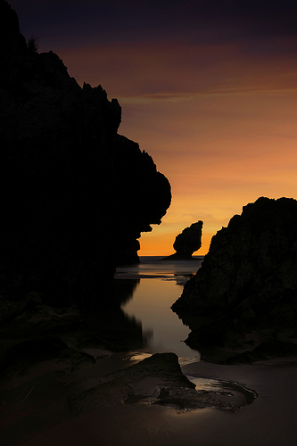 Splendid sunrise in reddish tones among the rocks of Buelna beach, Asturias
